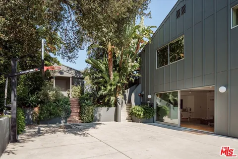 a living room with furniture a large window and a dining table