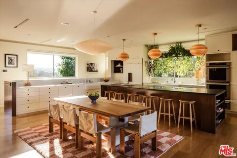 a kitchen with a table chairs stove and cabinets