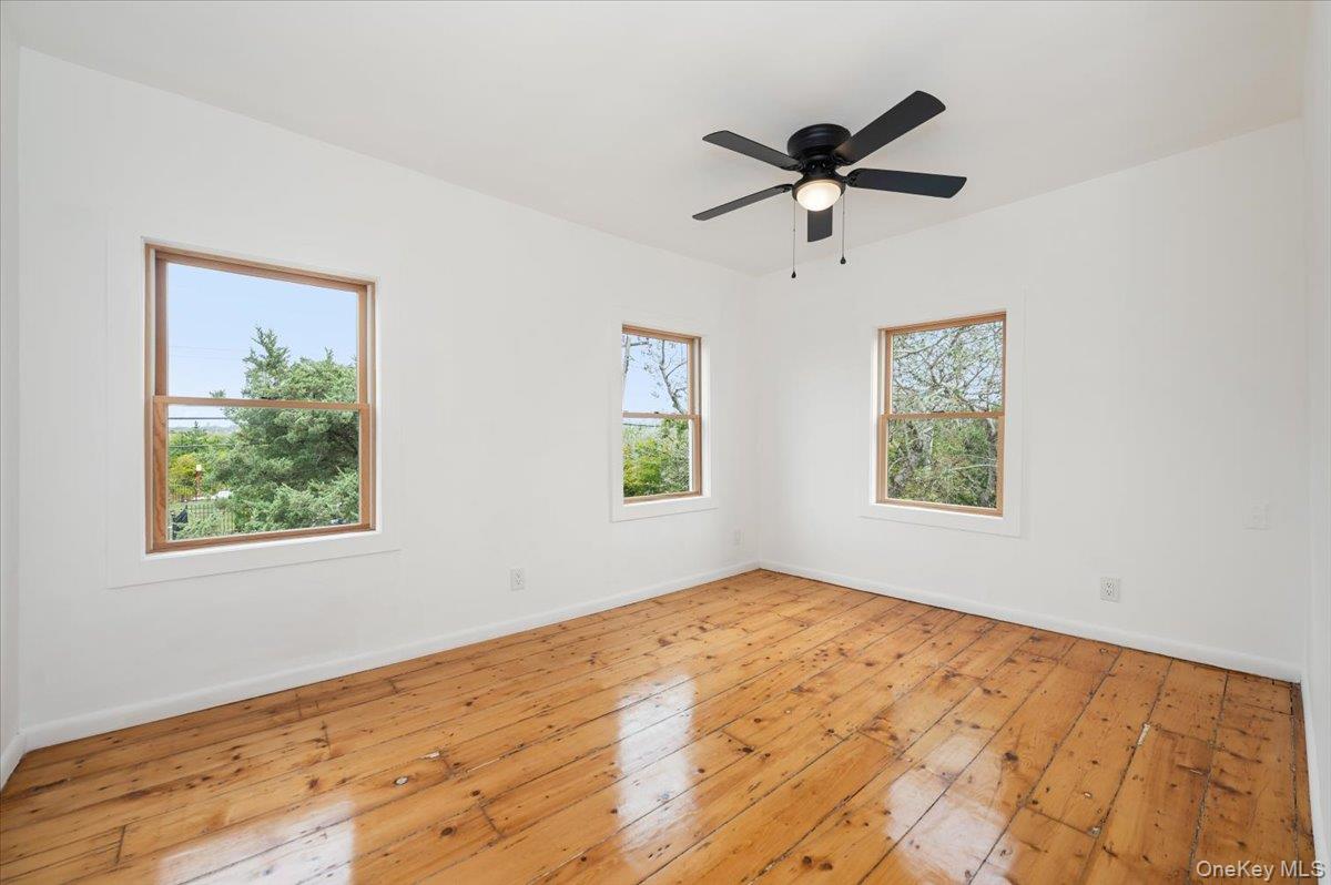 56 Oak Beach Road Babylon, NY 11702 - Photo 21 of 30 Bedroom with original refinished wide plank hardwood floors and new Anderson windows.