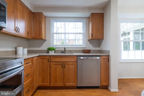 a kitchen with stainless steel appliances wooden cabinets and a stove top oven