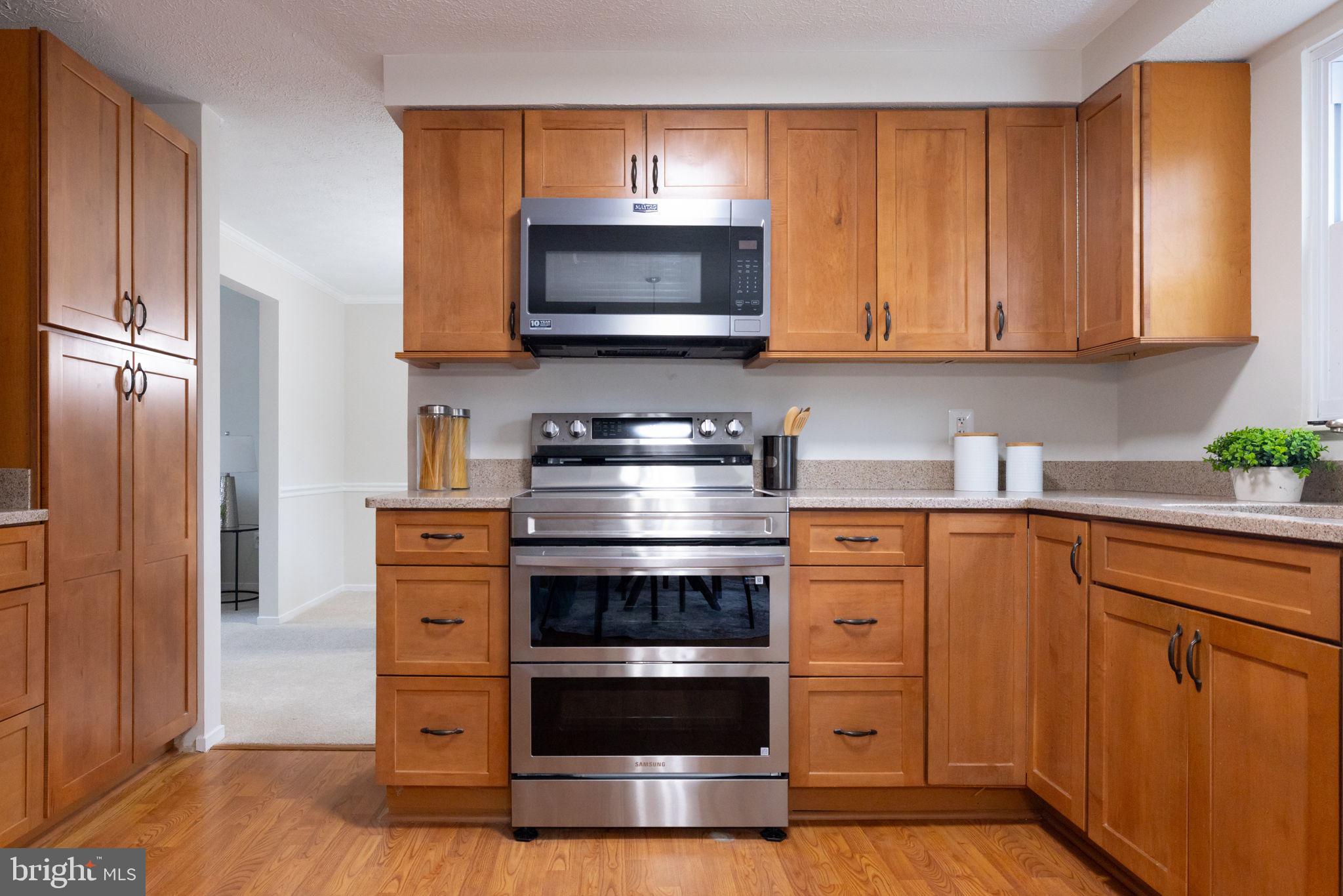 5755 Heming Avenue Springfield, VA 22151 - Photo 18 of 71 a kitchen with stainless steel appliances wooden cabinets and a stove top oven