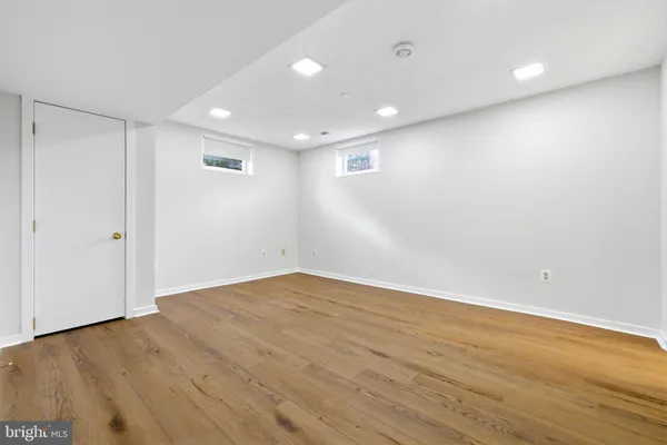 an empty room with wooden floor and entryway