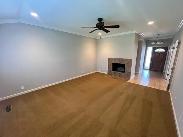 an empty room with windows and fireplace