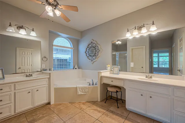 a spacious bathroom with a double vanity sink mirror and bathtub