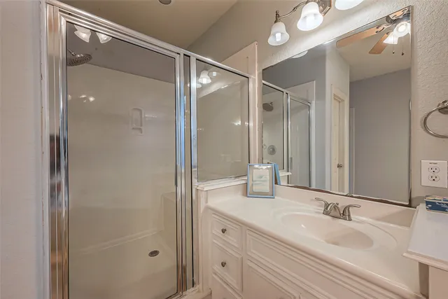 a bathroom with a granite countertop sink mirror and shower