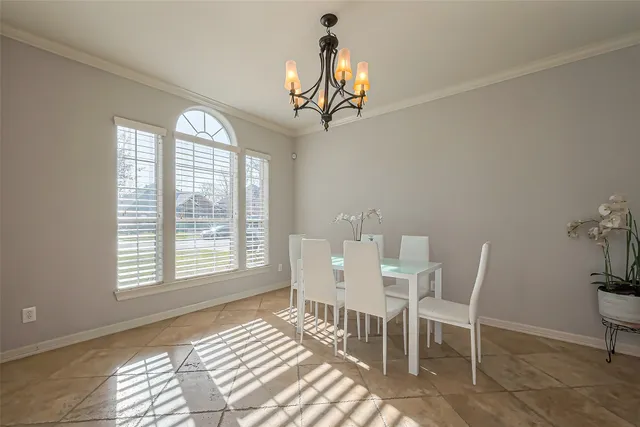 a dining room with wooden floor a chandelier a glass table and windows