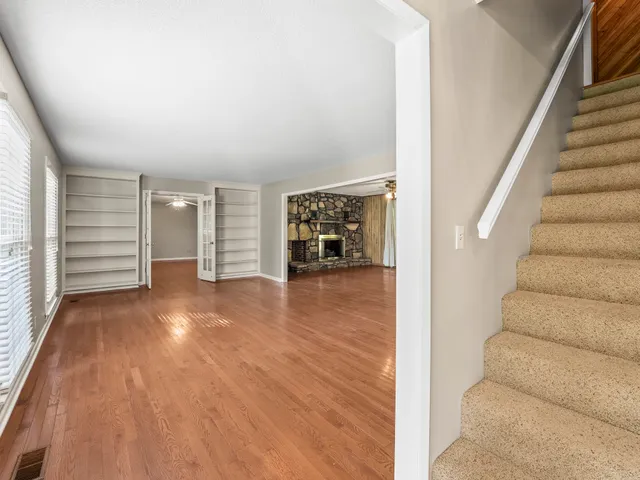 an empty room with wooden floor and windows