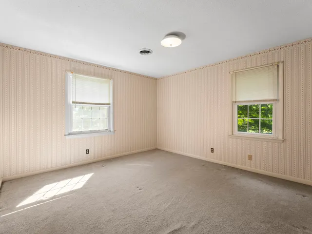 an empty room with closet and a ceiling fan