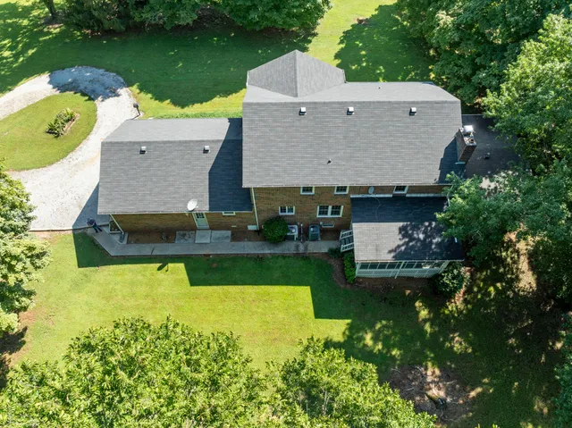 an aerial view of a house having yard with a swimming pool