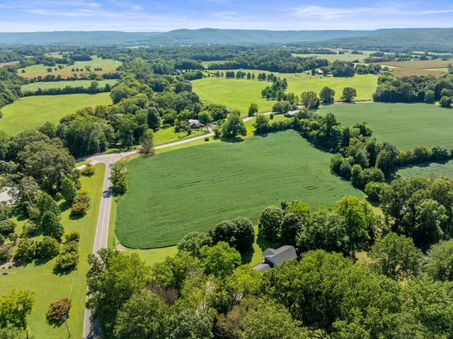 an aerial view of a residential houses with outdoor space and lake view