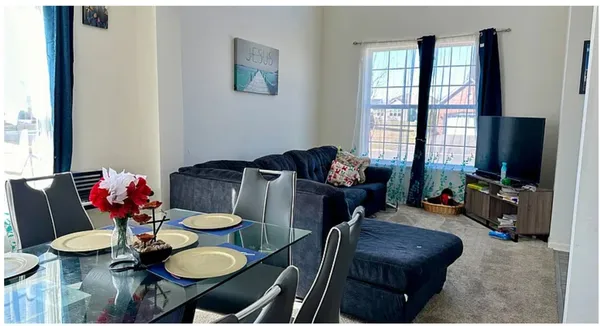 a living room with furniture and floor to ceiling windows