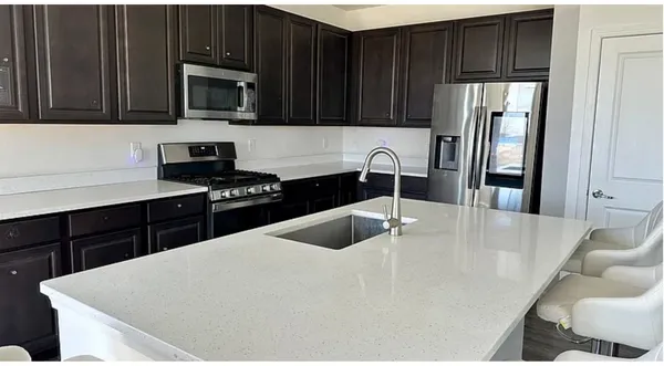 a kitchen with a sink a stove and microwave
