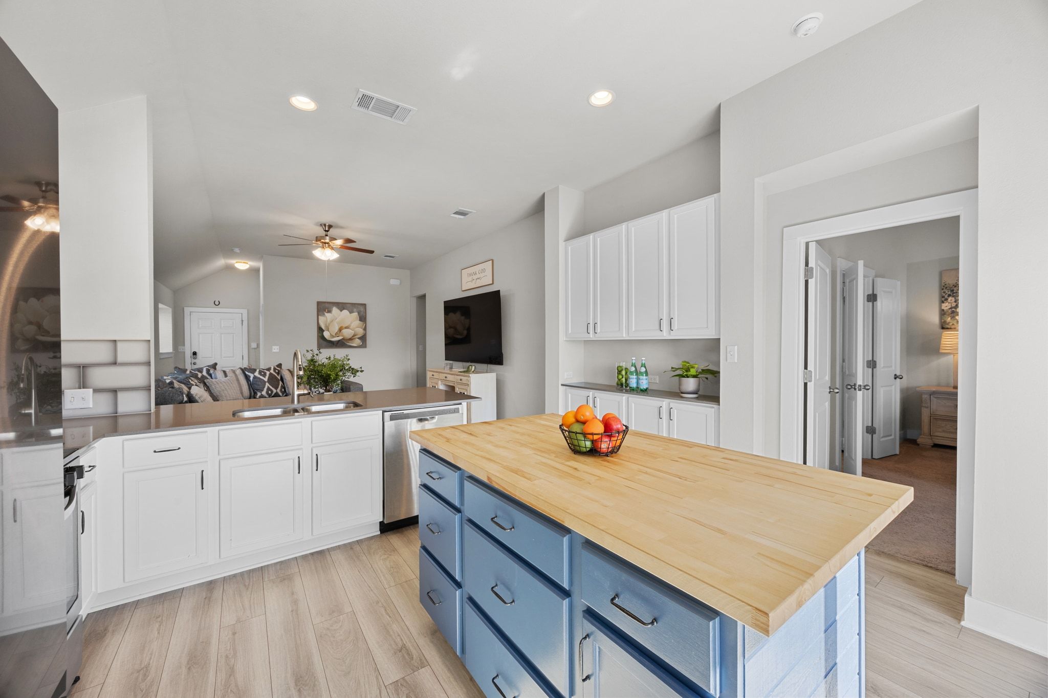 4807 Portillo Way Pflugerville, TX 78660 - Photo 24 of 24 Kitchen with blue cabinetry, white cabinetry, open floor plan, stainless steel dishwasher, and light wood-type flooring