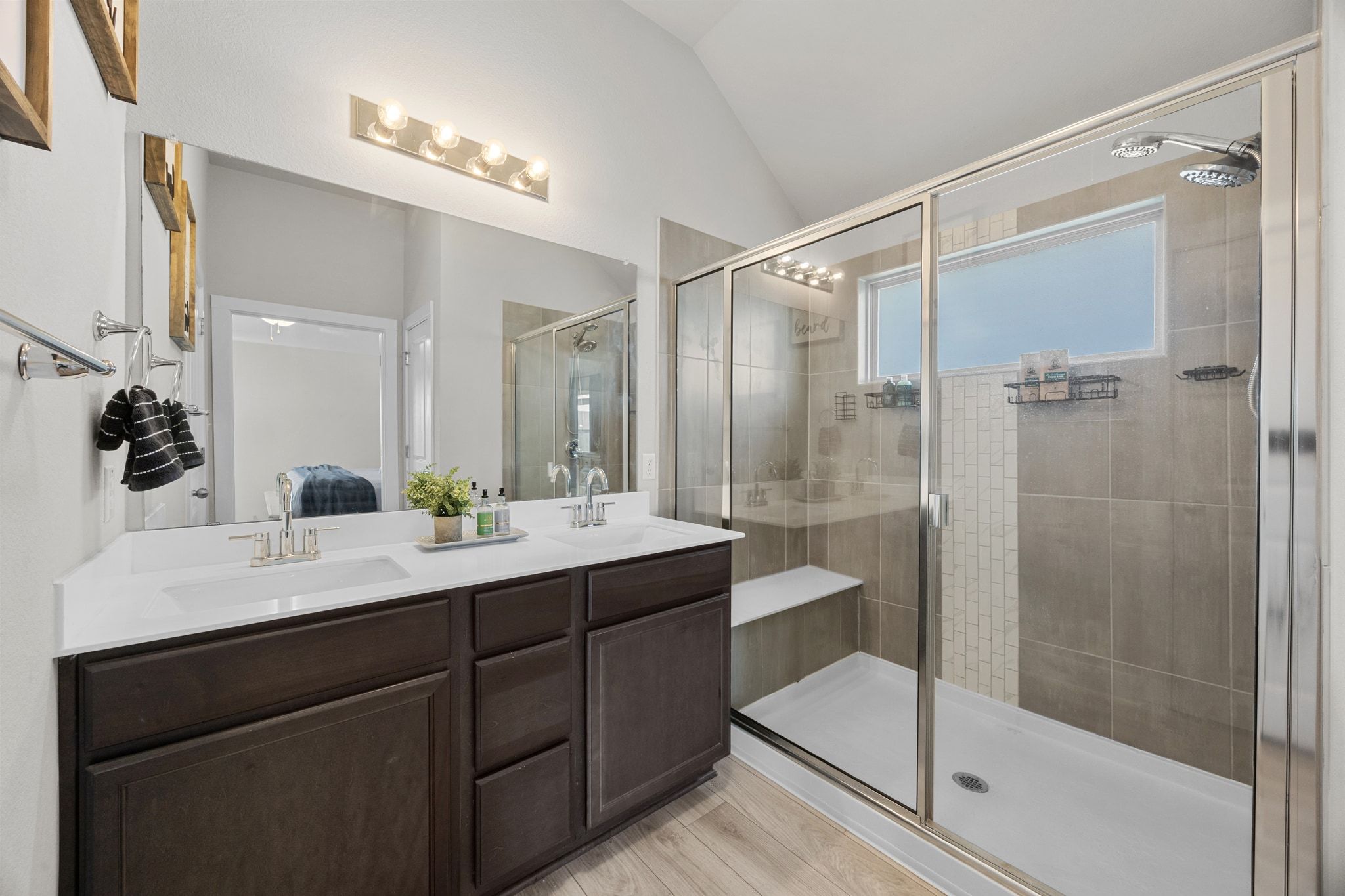 4807 Portillo Way Pflugerville, TX 78660 - Photo 14 of 24 Ensuite bathroom featuring double vanity, a stall shower, and lofted ceiling
