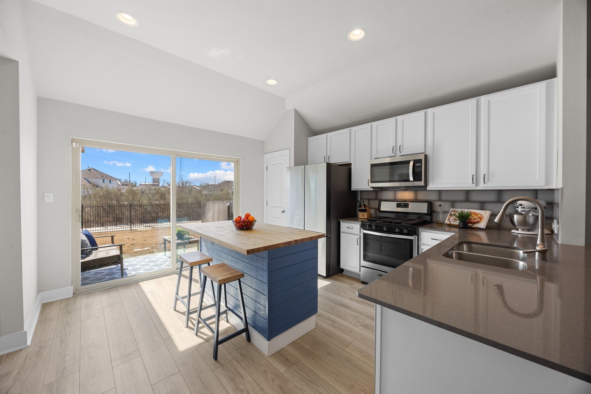 4807 Portillo Way Pflugerville, TX 78660 - Photo 8 of 24 Kitchen featuring stainless steel appliances, white cabinets, a breakfast bar, wood counters, and recessed lighting