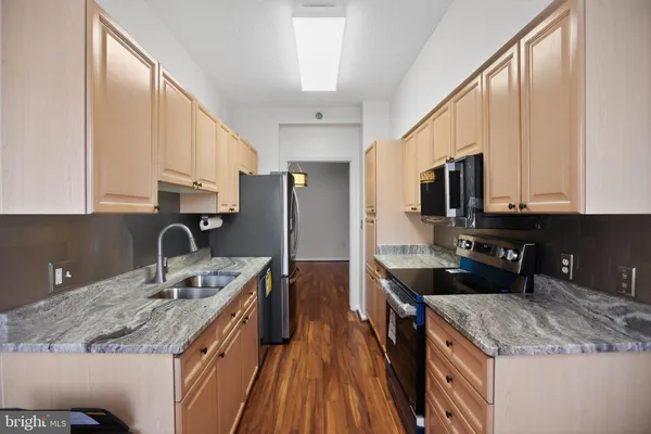 a kitchen with stainless steel appliances granite countertop a sink a stove and a microwave