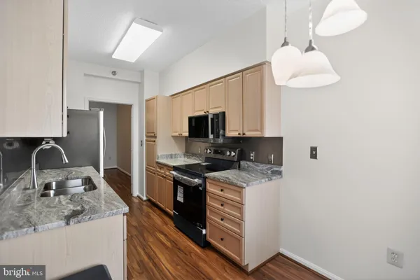 a kitchen with stainless steel appliances granite countertop a sink stove microwave and refrigerator
