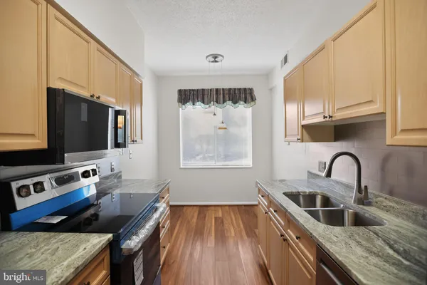 a kitchen with a stove a sink and a microwave