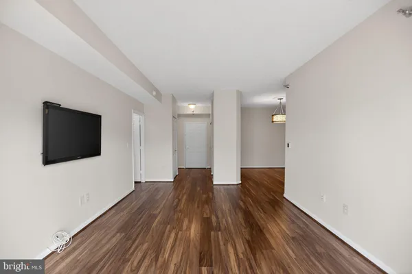 a view of a livingroom with wooden floor and a flat screen tv
