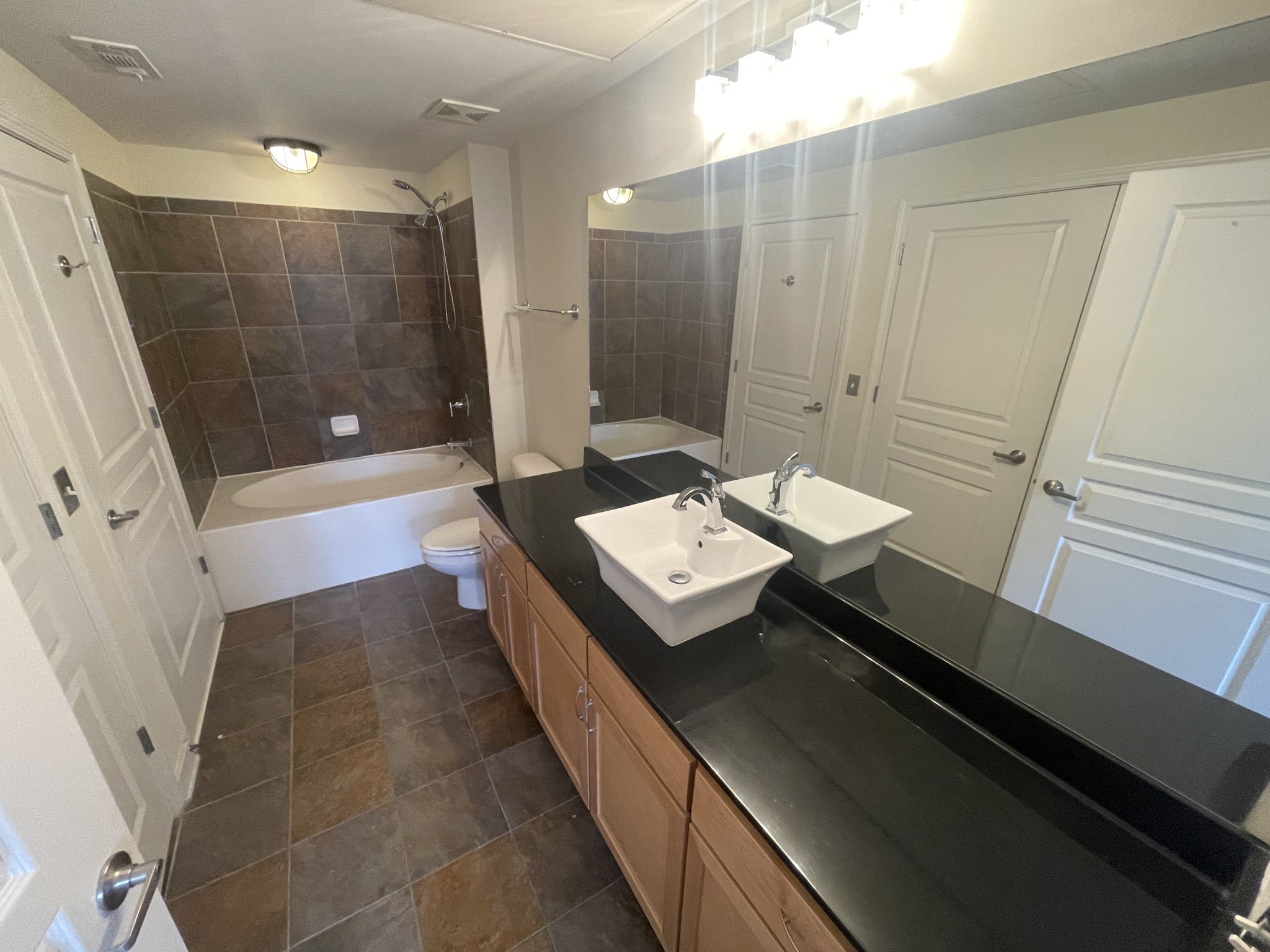 3000 Vanderbilt Place, Unit 412 Nashville, TN 37212 - Photo 9 of 13 a bathroom with a sink a toilet a mirror and shower