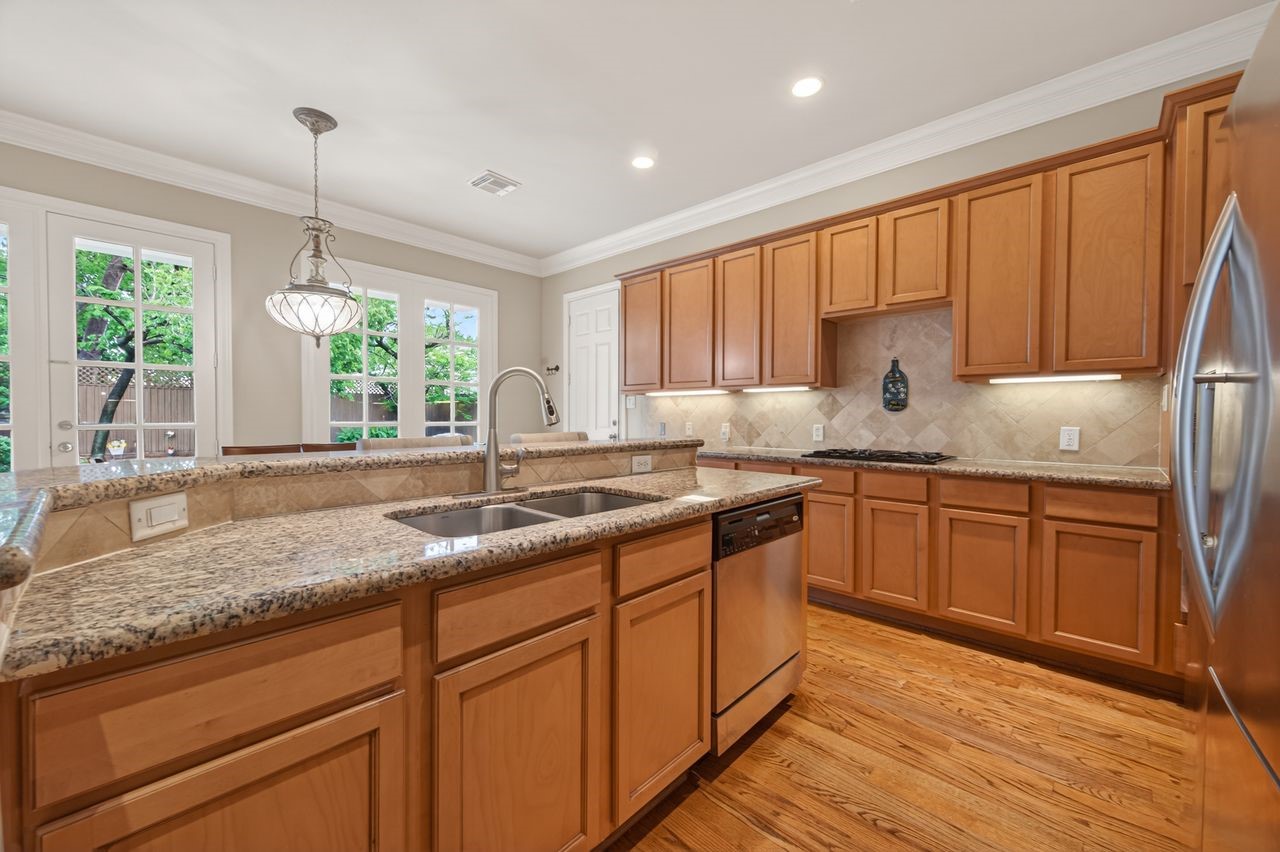 10932 Lasso Lane Houston, TX 77079 - Photo 10 of 38 a kitchen with granite countertop stainless steel appliances a sink window and cabinets