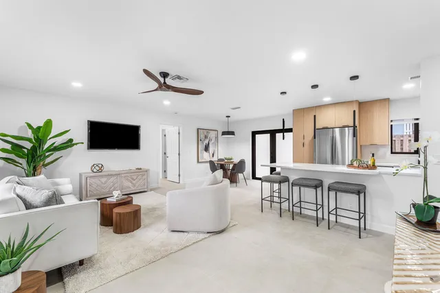 a white house with palm trees in the background