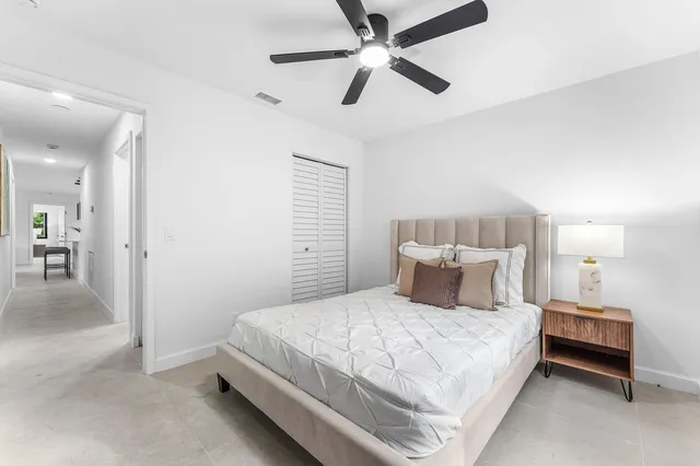 a backyard of a house with plants and large tree