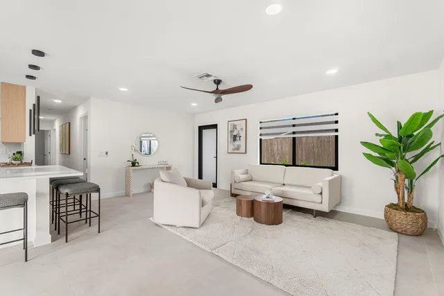 a living room with furniture a flat screen tv and a large window