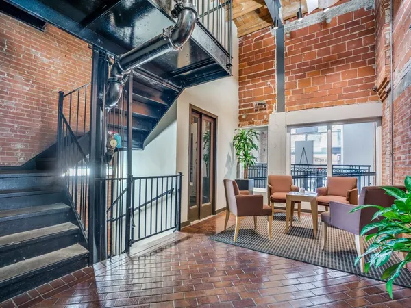 a view of a patio with couches potted plants and wooden floor