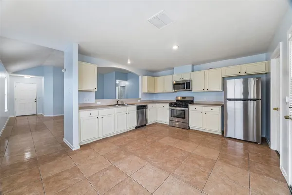 a large kitchen with cabinets and stainless steel appliances