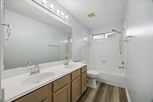 a bathroom with a double vanity sink toilet mirror and shower