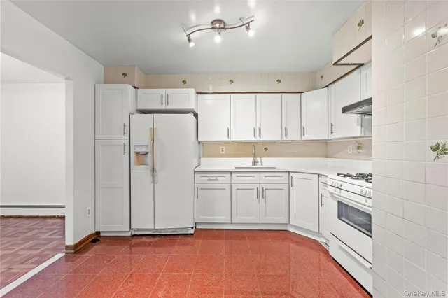 a kitchen with white cabinets and white appliances