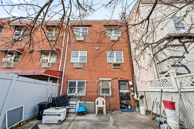 a front view of a building with large trees