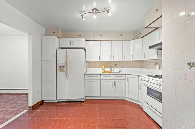 a kitchen with white cabinets and white appliances