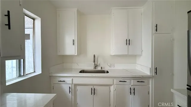 a kitchen with a sink cabinets and window