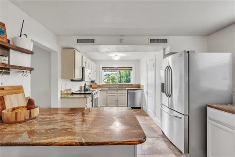 a kitchen with stainless steel appliances granite countertop a refrigerator sink and stove