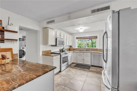 a kitchen with a sink cabinets and window