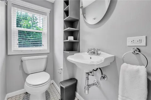 a bathroom with a sink toilet and a mirror