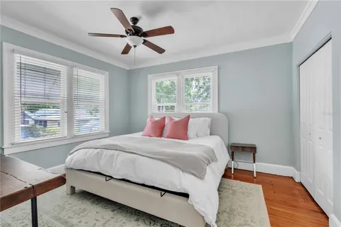 a bedroom with a bed and wooden floor