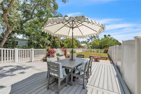 a view of deck with furniture and umbrella