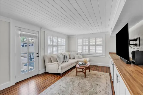 a living room with furniture a flat screen tv and a large window