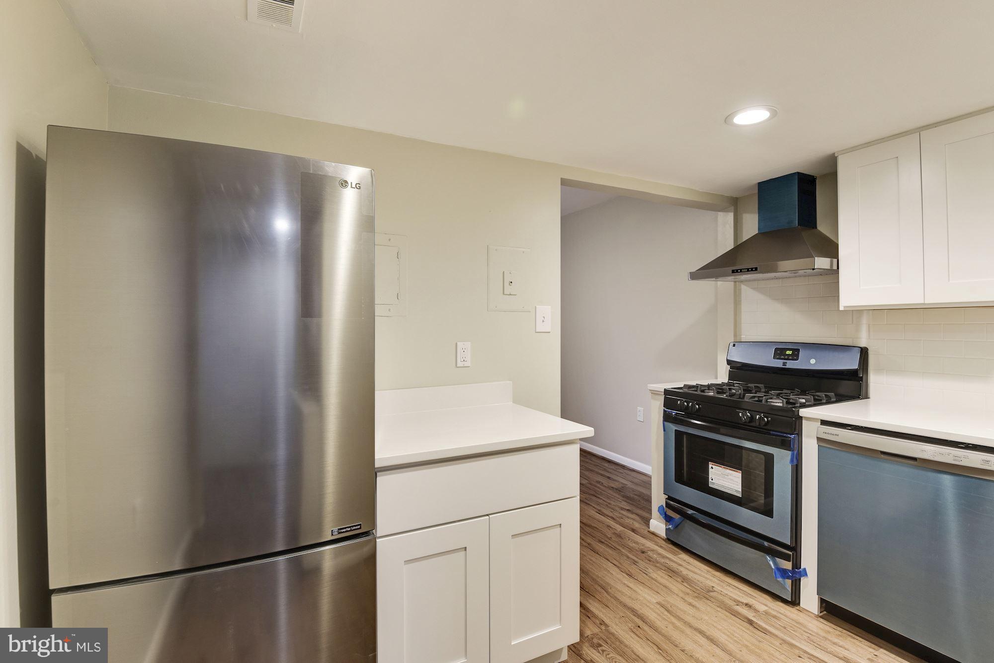 1538 Northgate Square, Unit 1A Reston, VA 20190 - Photo 2 of 18 a kitchen with stainless steel appliances granite countertop a refrigerator a stove and a sink with wooden floor