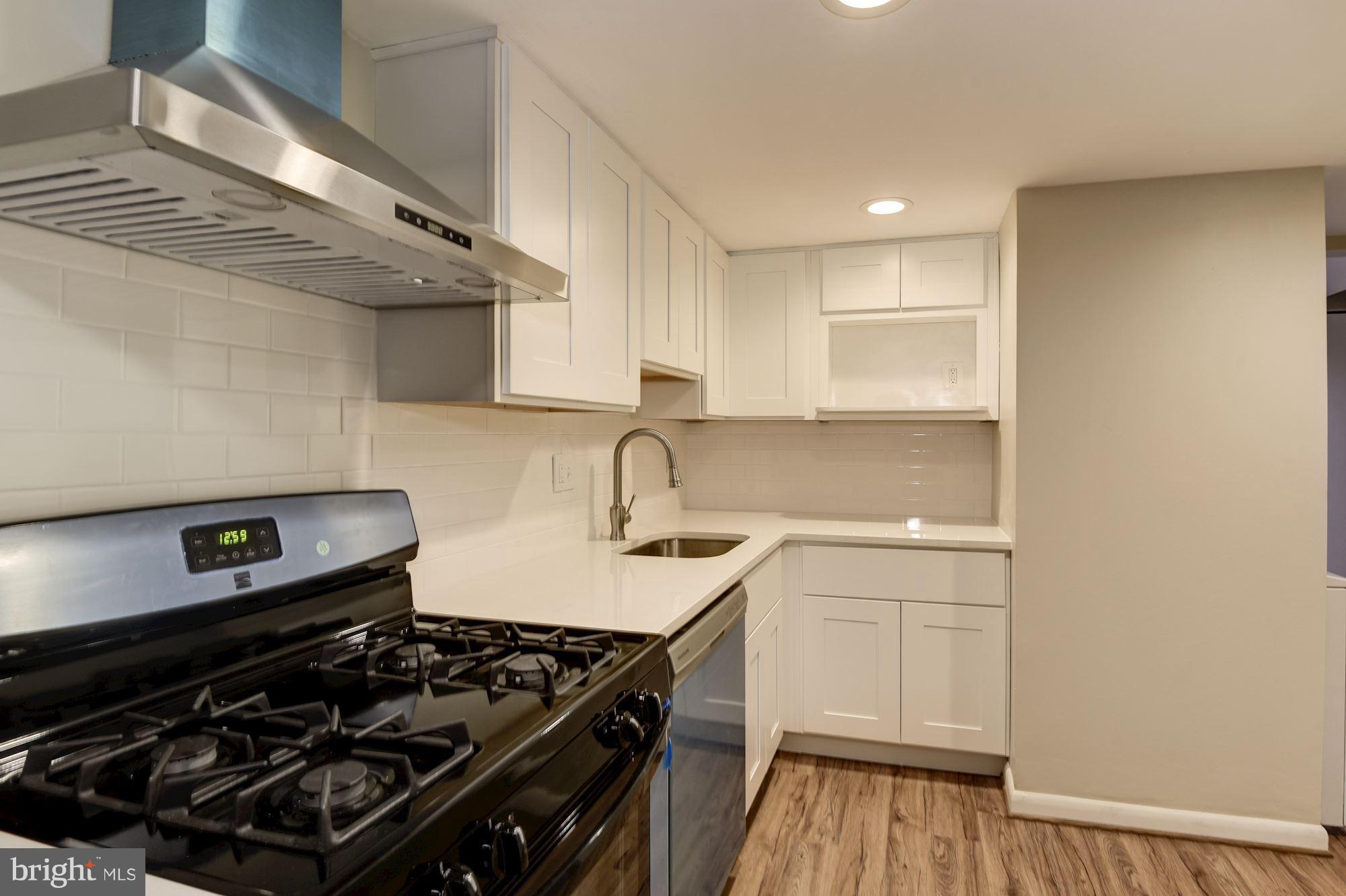 1538 Northgate Square, Unit 1A Reston, VA 20190 - Photo 5 of 18 a kitchen with a stove and a wooden floor