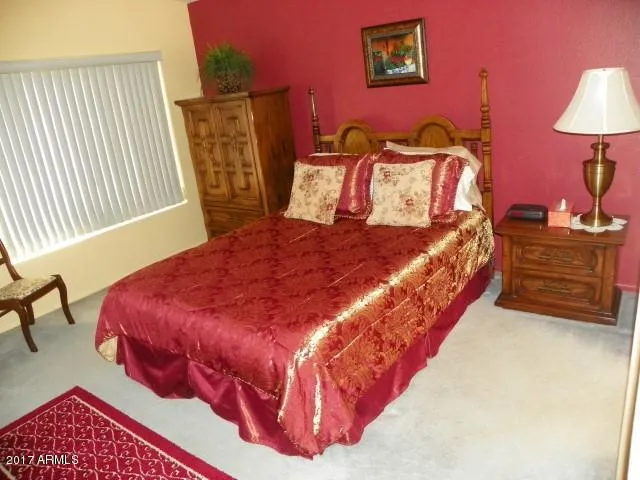 a large bed sitting in a bedroom next to a lamp