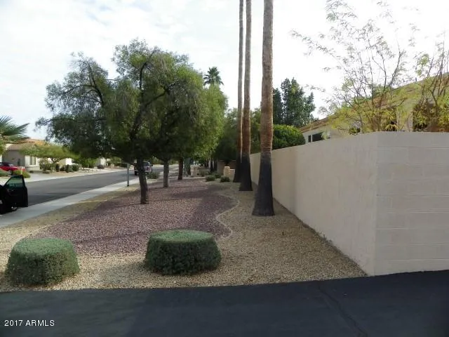 a view of a hallway with wooden floor and a bathroom