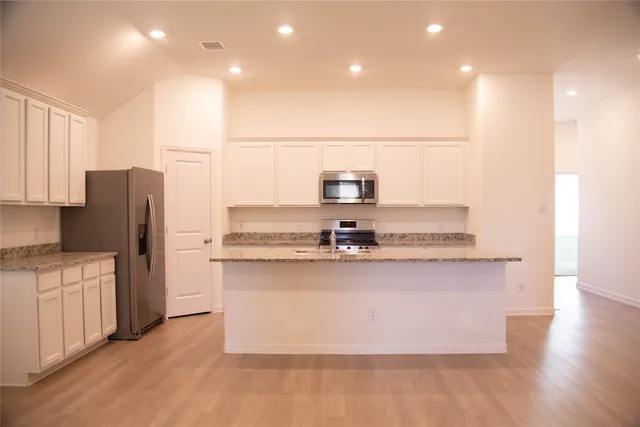 a kitchen with stainless steel appliances a refrigerator and a stove top oven