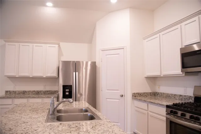 a kitchen with stainless steel appliances granite countertop a refrigerator sink and stove