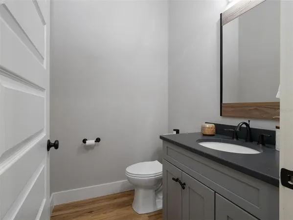 a bathroom with a granite countertop toilet a sink and a mirror