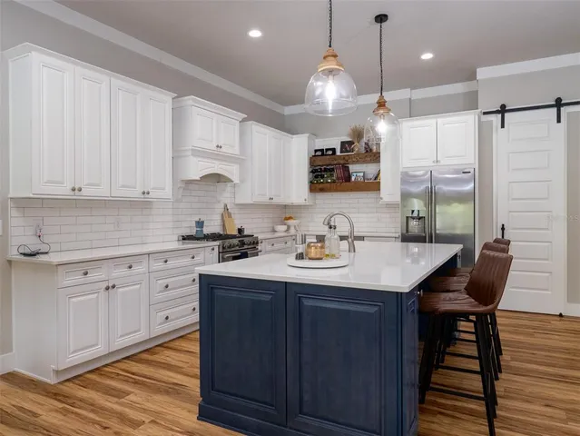 a kitchen with kitchen island granite countertop a sink cabinets and wooden floor