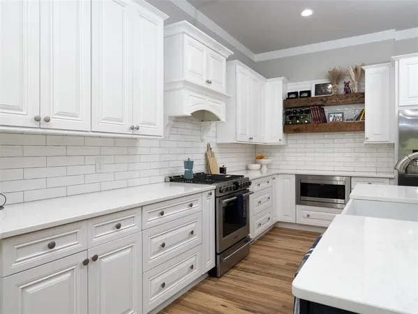 a kitchen with granite countertop white cabinets and stainless steel appliances